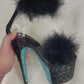 Black and baby blue glitter 7" Heels with baby blue glitter bottoms, and black glitter on the platform and heels, clear straps, black soles, black feathers over the toe straps, and black feathers around the ankle straps.