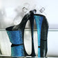 Platform heels with clear straps, and dual Ombre with blue and black glitter. Shades of blue starting at the front of the platform, and back of the heels, blending to black under the arch, and down the inside of the heels. Black soles.