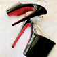 Black patent platform heels with clear straps. Red glitter on the arches and inside of heels. Black soles.