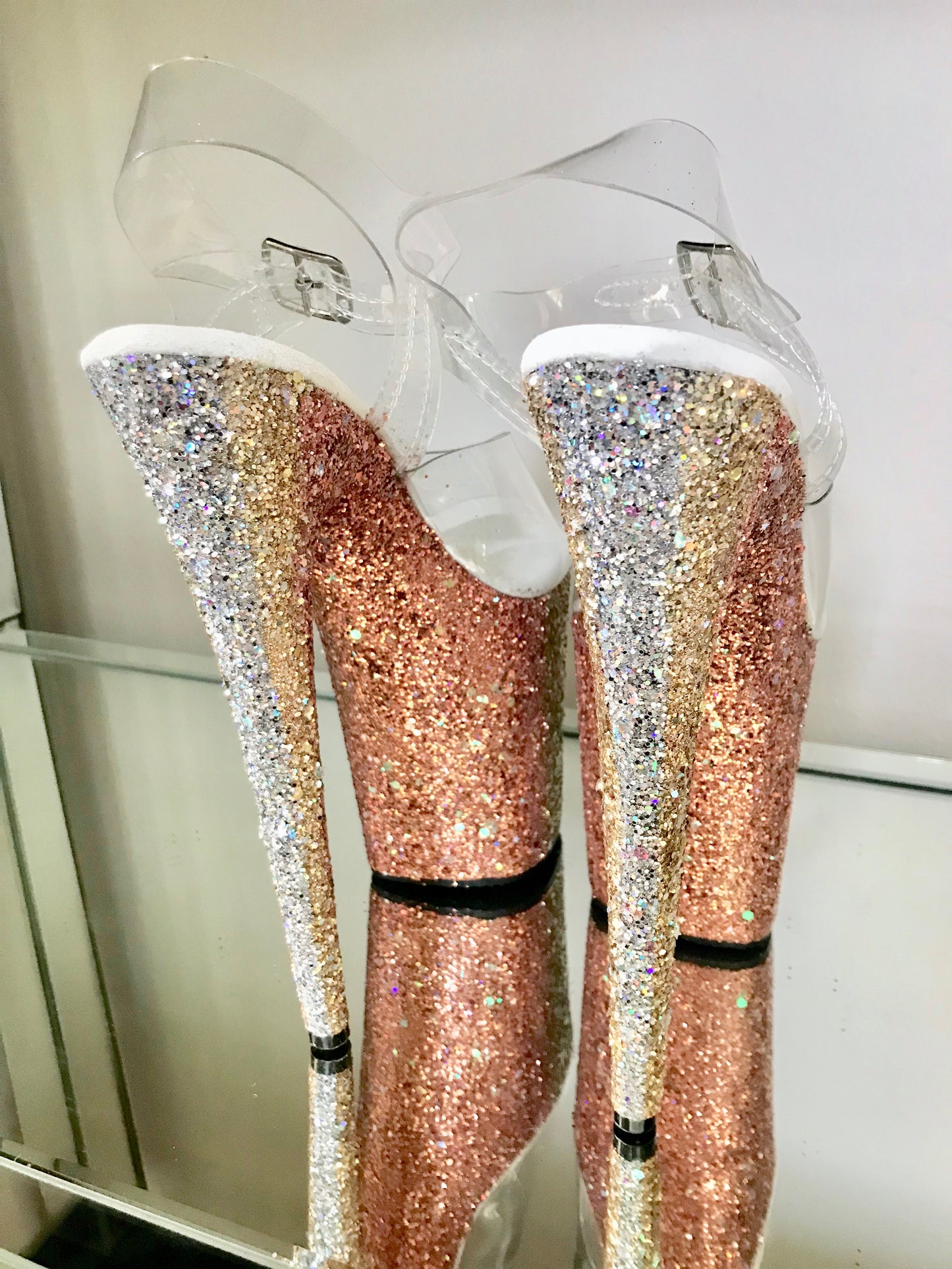 Platform heels with clear straps, and dual Ombre with gold and orange glitter. Shades of gold starting at the front of the platform, and back of the heels, blending to orange glitter under the arch, and down the inside of the heels. White soles.