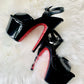 Black patent platform heels with black straps. Red glitter on the arches and inside of heels. Black soles.