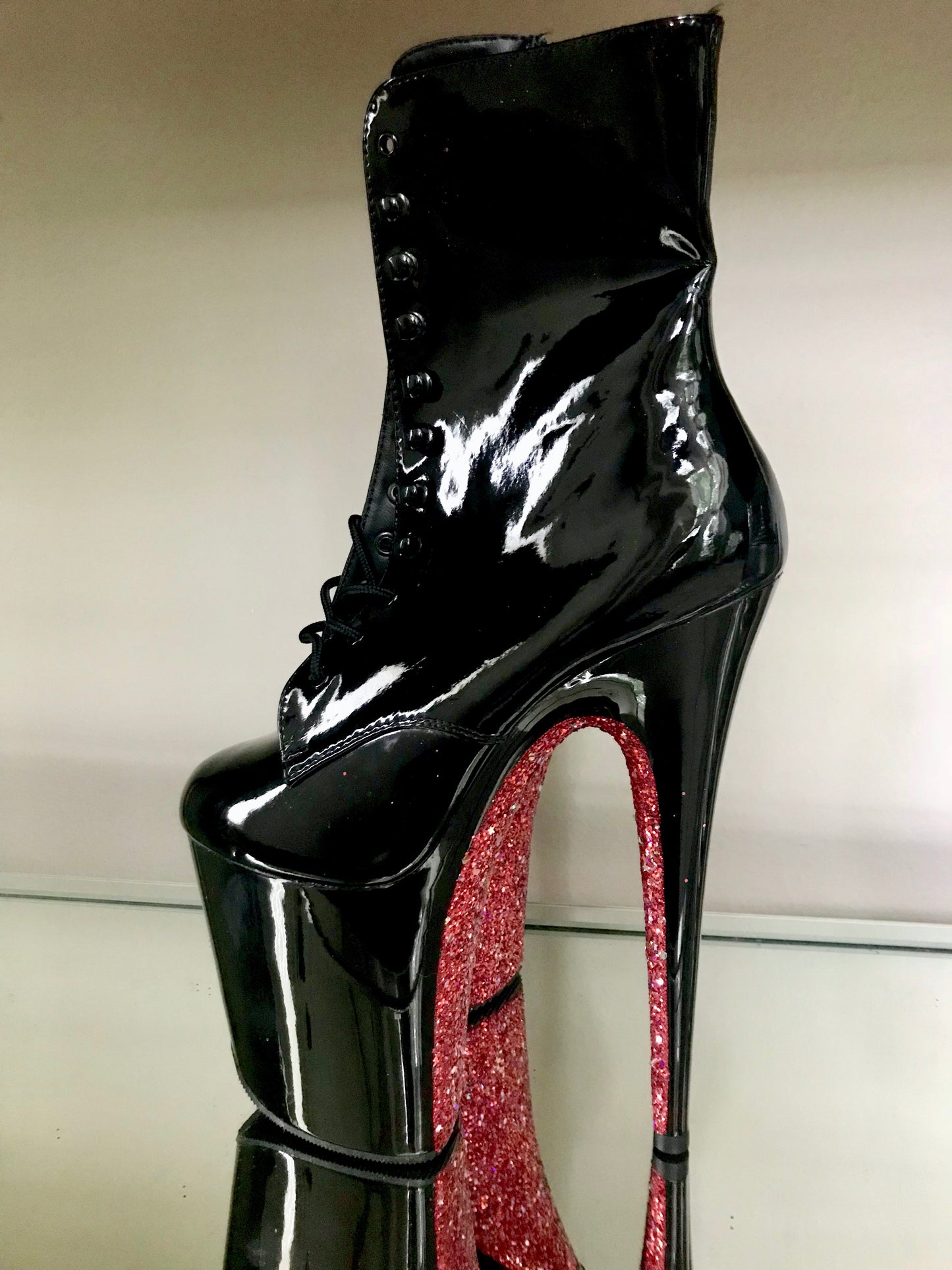 Black patent platform boots with black laces, and inside zipper. Red glitter on the arches and inside of heels.