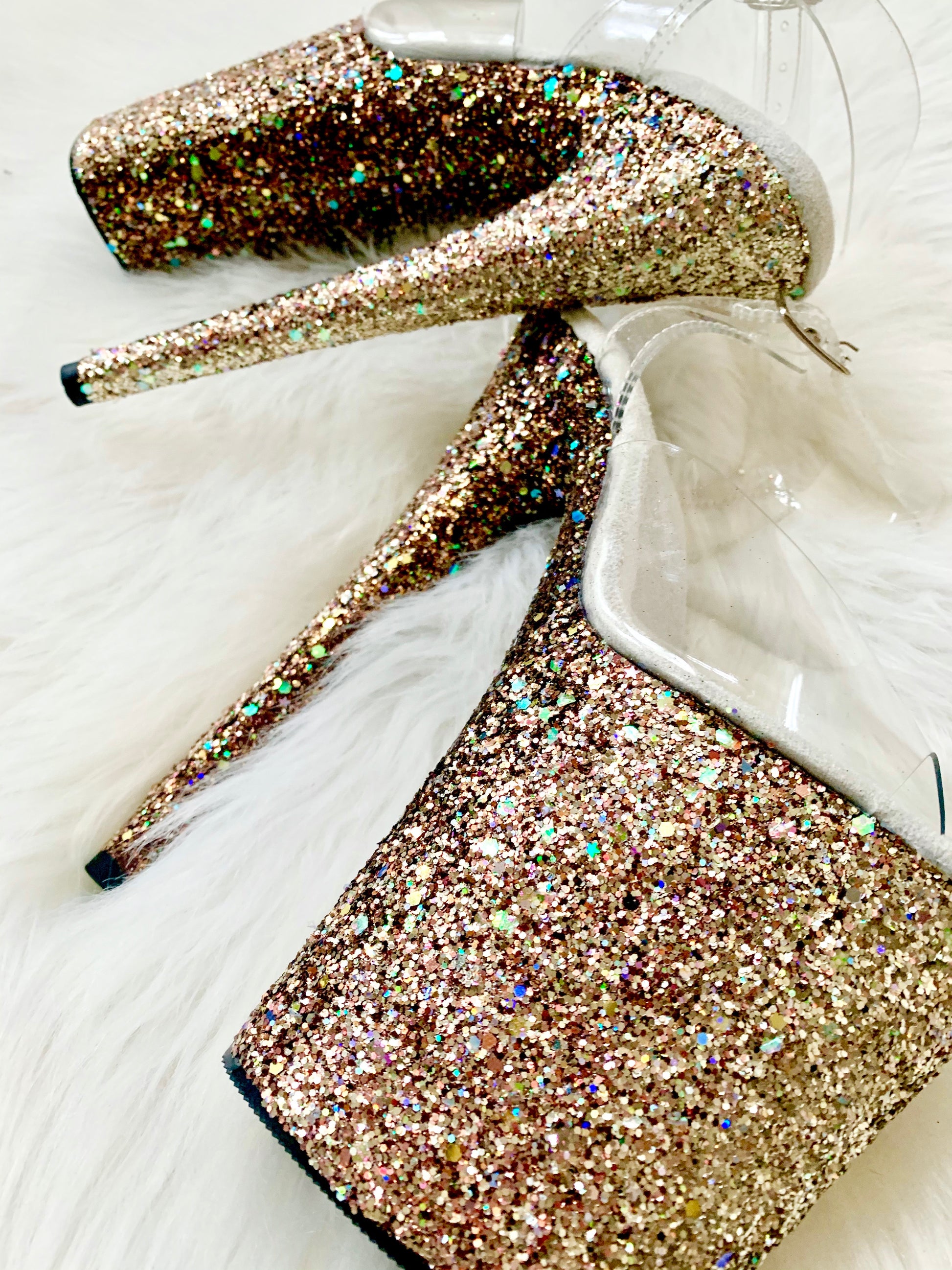 Platform heels with clear straps, and dual Ombre with gold, rose gold and bronze glitter. Shades of gold and rose gold glitter starting at the front of the platform, and back of the heels, blending to bronze glitter under the arch, and down the inside of the heels. White soles.