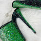 Platform heels with clear straps, and dual Ombre with green and black glitter. Shade of green starting at the front of the platform, and back of the heels, blending to black under the arch, and down the inside of the heels. Black soles.