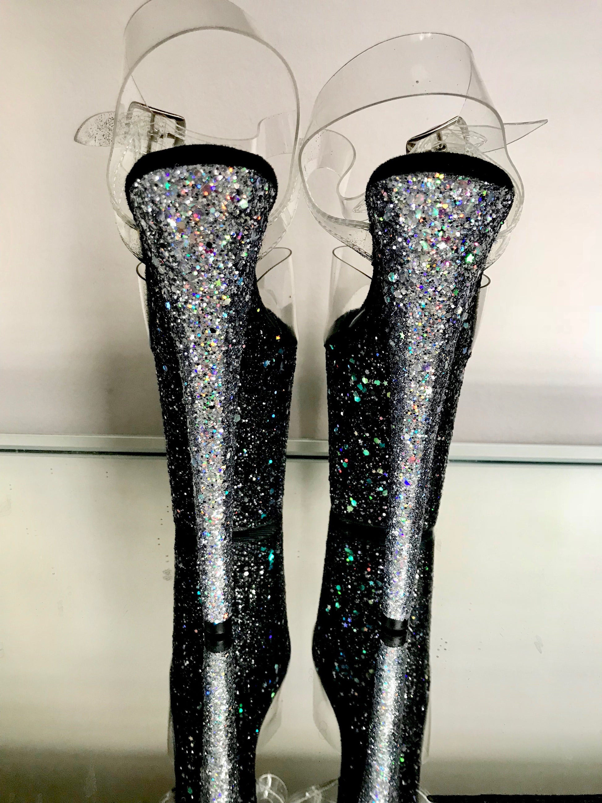 Platform heels with clear straps, and dual Ombre with silver and black glitter. Shades of silver glitter starting at the front of the platform, and back of the heels, blending to black glitter under the arch, and down the inside of the heels. Black soles.