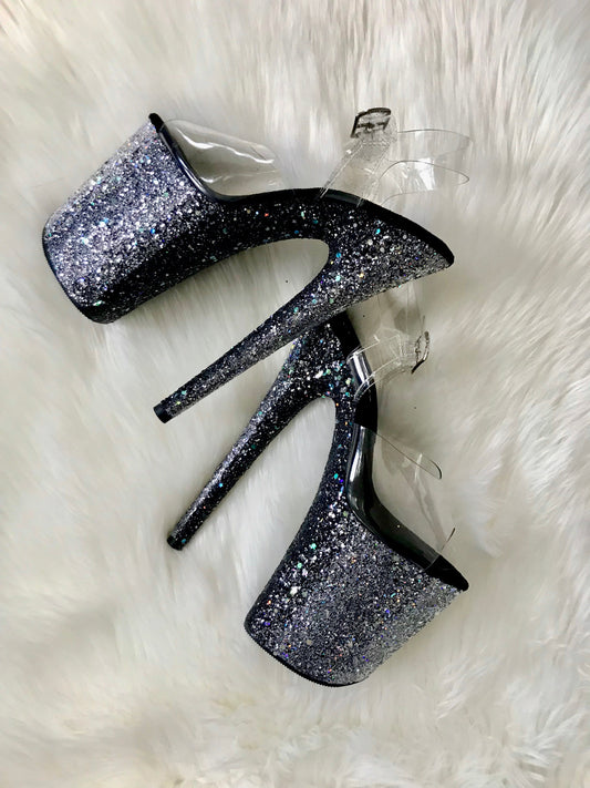 Platform heels with clear straps, and dual Ombre with silver and black glitter. Shades of silver glitter starting at the front of the platform, and back of the heels, blending to black glitter under the arch, and down the inside of the heels. Black soles.