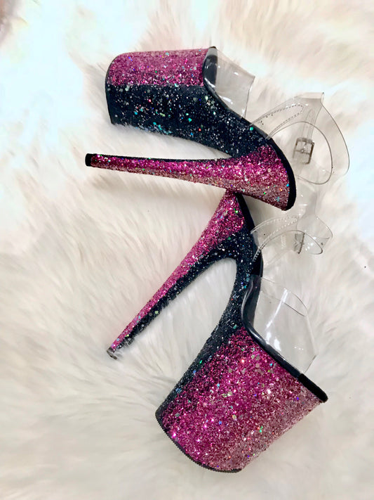 Platform heels with clear straps, and dual Ombre with blush, magenta, and black glitter. Shades of blush and magenta glitter starting at the front of the platform, and back of the heels, blending to black glitter under the arch, and down the inside of the heels. Black soles.